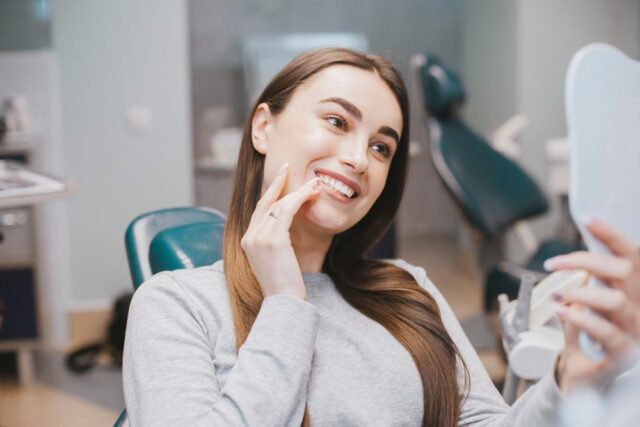 woman looking at her new smile at the dentist